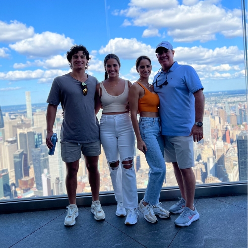 Group posing with city skyline view.